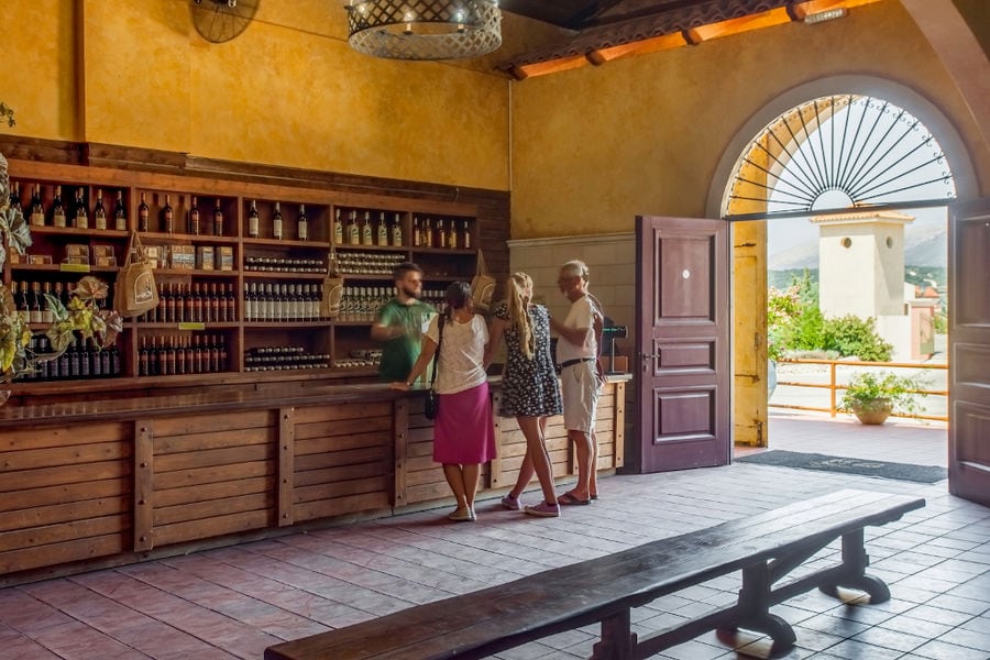 inside Orealios Gaea entrance with an arcade on top of the door and reception with tourists